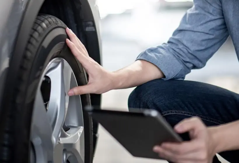 Man inspecting vehicle tire